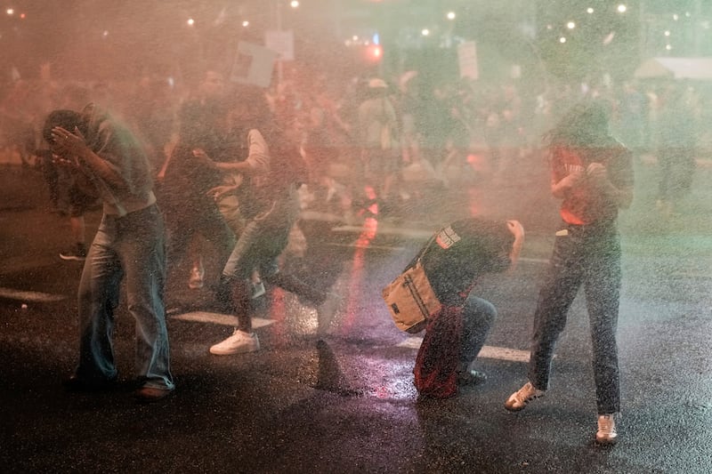 Police use water cannon to disperse demonstrators blocking a road during a protest against Israeli prime minister Benjamin Netanyahu’s government (Leo Correa/AP)