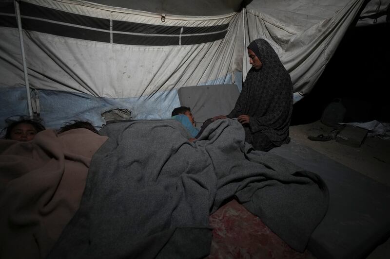 A mother watches over her children in their tent at a camp for displaced people in Deir al-Balah, Gaza Strip (Abdel Kareem Hana/AP)