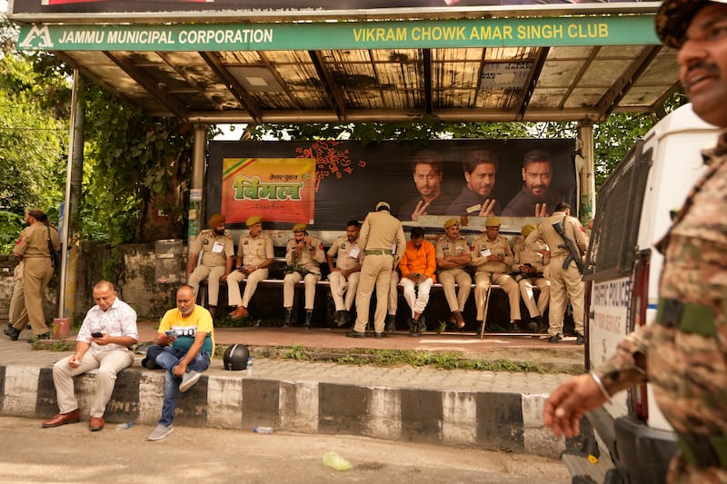 Security workers rest under a passenger shed outside a counting centre in Jammu, India (Channi Anand/AP)