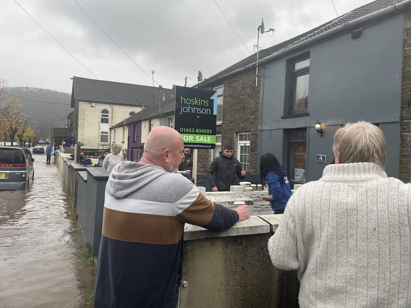 Residents attend to their properties on Sion Street in Pontypridd, Wales, following flooding