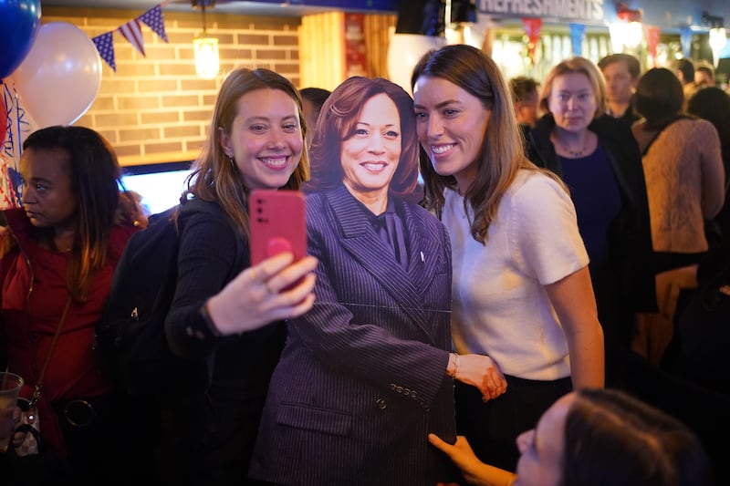 People pose for photos with a cardboard cutout of Kamala Harris at the Democrats Abroad US election-watching event in central London