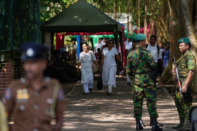 Workers leave a poll counting centre following the parliamentary election in Colombo, Sri Lanka (Eranga Jayawardena/AP)