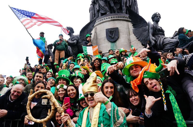 A performer dressed as St Patrick poses with spectators during the St Patrick’s Day Parade in Dublin in 2023