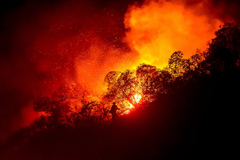 A firefighter battles the Lilac Fire near the Bonsall community of San Diego (Noah Berger/AP)