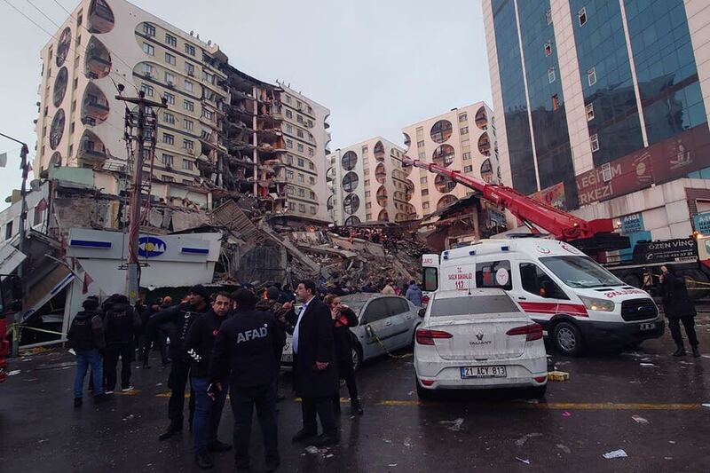 Rescue workers and medical teams try to reach trapped residents in a collapsed building following and earthquake in Diyarbakir, south-eastern Turkey (Mahmut Bozarsan/AP)
