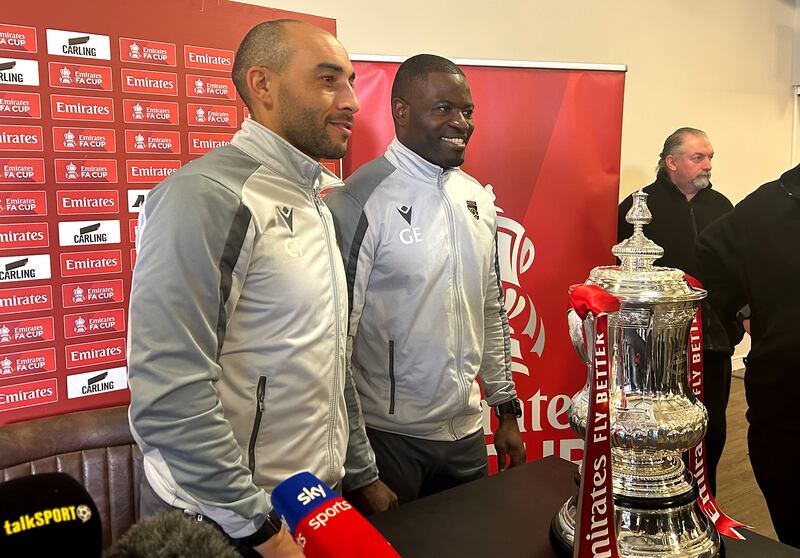 Elokobi, right, and assistant coach Craig Fagan pose with the FA Cup trophy