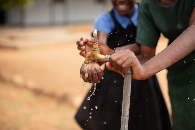 Students use their school water tap, Kazungula district, Zambia. November 2023. (WaterAid/Laura Pannack)