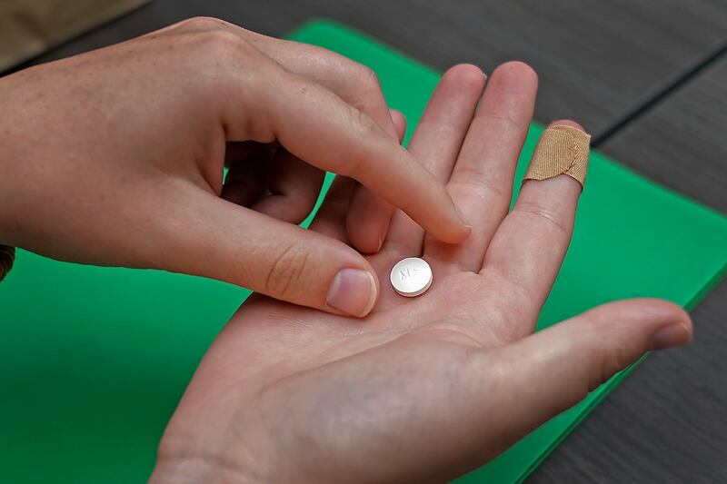 A patient prepares to take the first of two combination pills, mifepristone, for medication abortion (Charlie Riedel/AP)