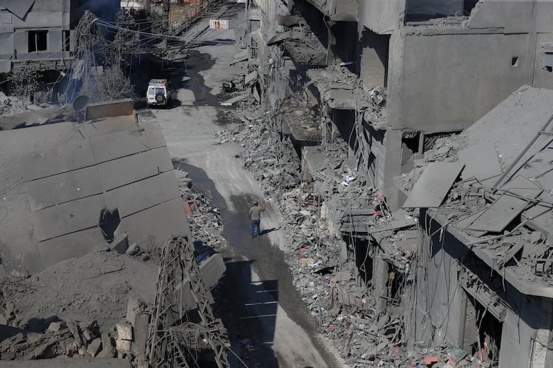 A man walks amid destroyed buildings in the town of Nabatiyeh, south Lebanon, following Israeli air strikes on Saturday night (Mohammed Zaatari/AP)