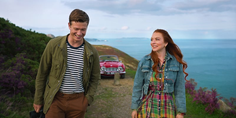 James Thomas and Lindsay Lohan walking on a cliff top smiling