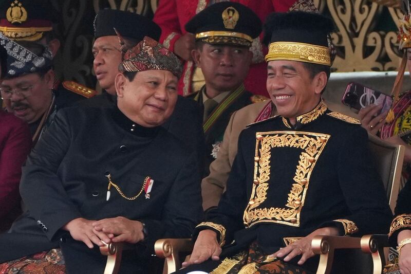 Defence Minister and president-elect Prabowo Subianto, left, shares a moment with then-president Joko Widodo during the ceremony marking Indonesia’s 79th anniversary of independence, August 2024 (Achmad Ibrahim/AP)