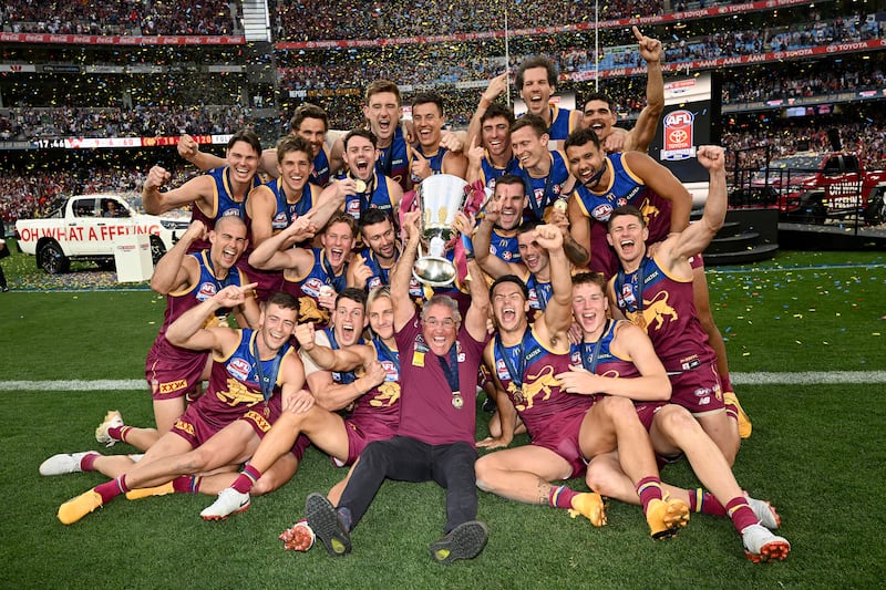 MELBOURNE, AUSTRALIA - SEPTEMBER 28: Brisbane Lions players and coach Chris Fagan, celebrate with the Premiership Cup after winning the AFL Grand Final match between Sydney Swans and Brisbane Lions at Melbourne Cricket Ground, on September 28, 2024, in Melbourne, Australia. (Photo by Quinn Rooney/Getty Images)