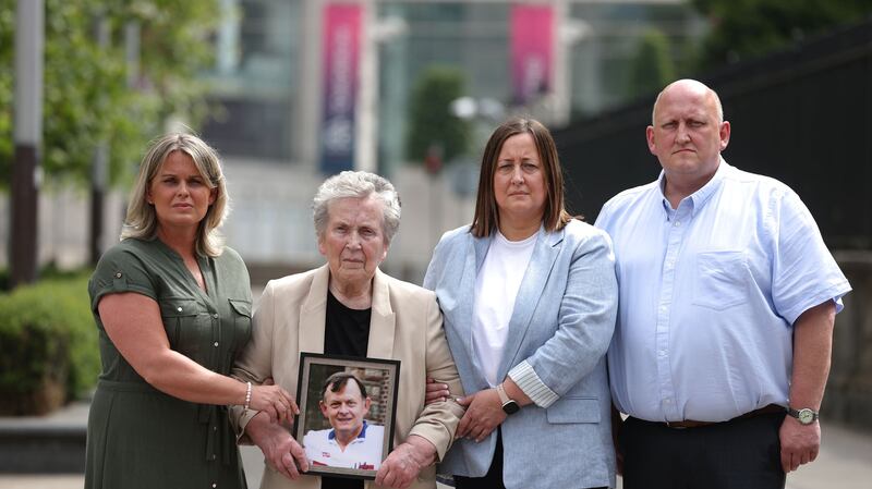 The widow of murdered GAA official Sean Brown, Bridie Brown holds a picture of her late husband with their daughters and son, (left to right) Clare Loughran, Siobhan Brown and Sean Brown (Liam McBurney/PA)