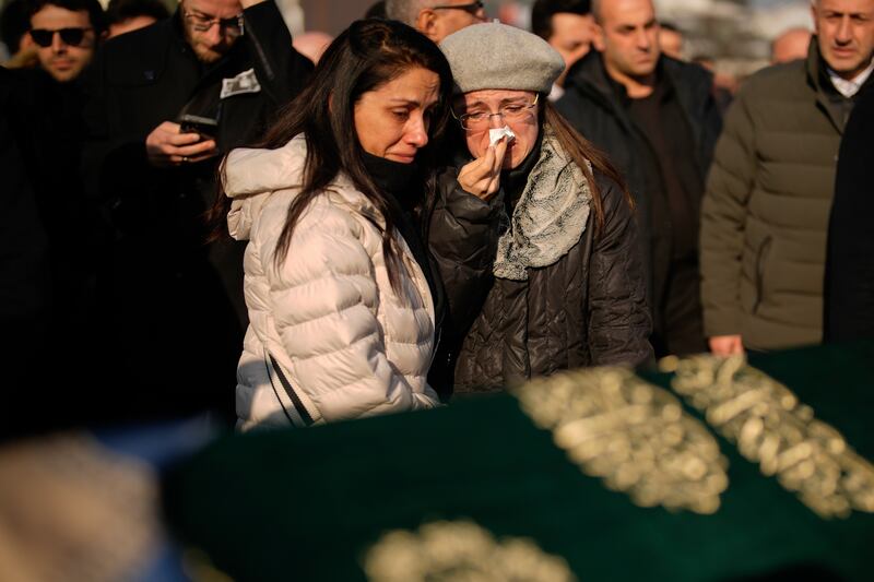 Relatives mourn over the coffin of Nedim Turkmen, one of victims who died in the hotel blaze (Emrah Gurel/AP)