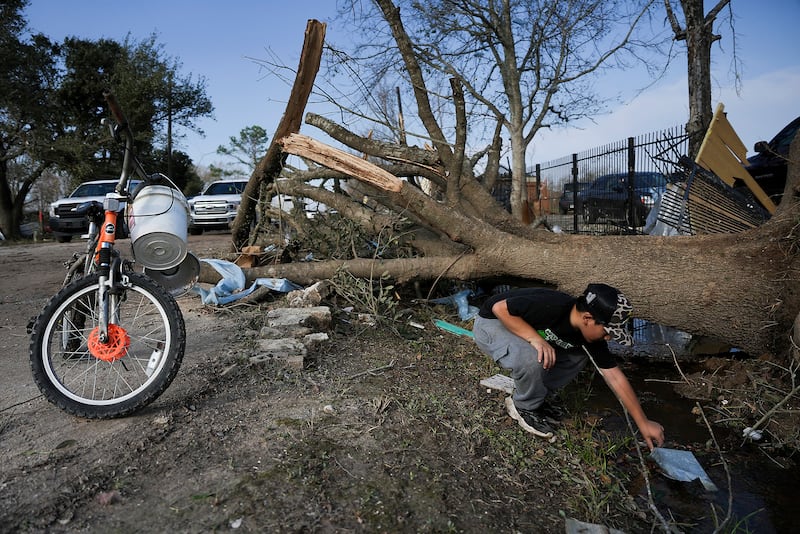 JC Betanzos, 11, looks for items from his sister’s business and things his deceased mother gave them that blew away during a tornado (Elizabeth Conley/Houston Chronicle/AP)