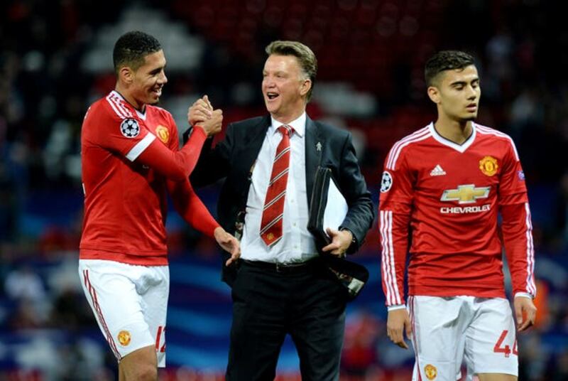 Former Manchester United manager Louis van Gaal celebrates with Chris Smalling