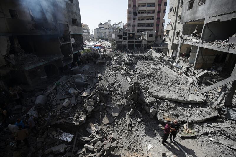 Palestinians look at the aftermath of an Israeli bombing in a refugee camp in the Gaza Strip (AP)