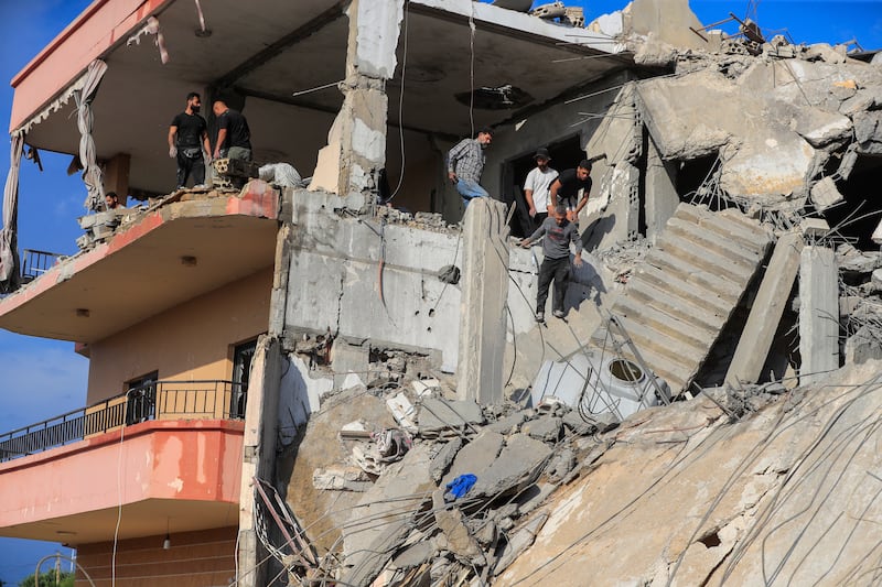 People searching for victims at a destroyed building hit in an Israeli airstrike, in Ghaziyeh, south Lebanon, on Sunday (Mohammed Zaatari/AP)