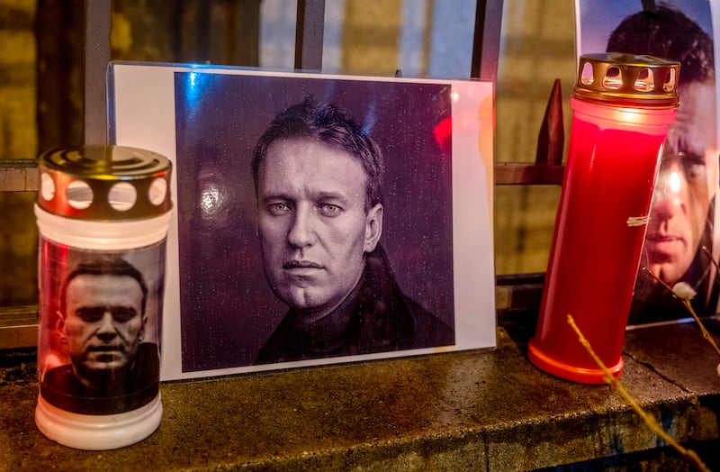 Candles and a photo of Russian opposition leader Alexei Navalny are placed at the fence of the Russian consulate in Frankfurt, Germany (AP Photo/Michael Probst)