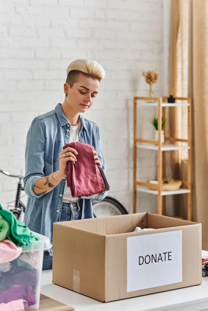 woman putting clothes in box to donate to charity