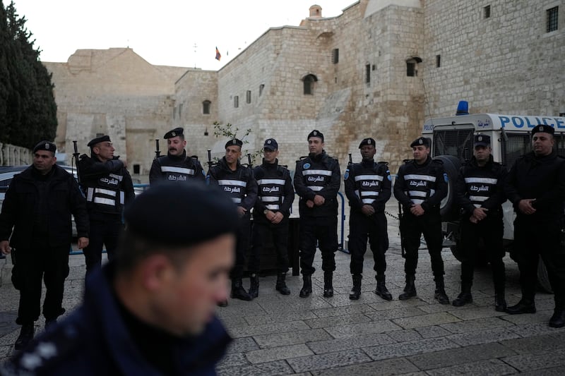 Palestinian police line up next to the Church of the Nativity, traditionally believed to be the birthplace of Jesus, on Christmas Eve, though the usual crowds are not expected (AP Photo/Matias Delacroix)