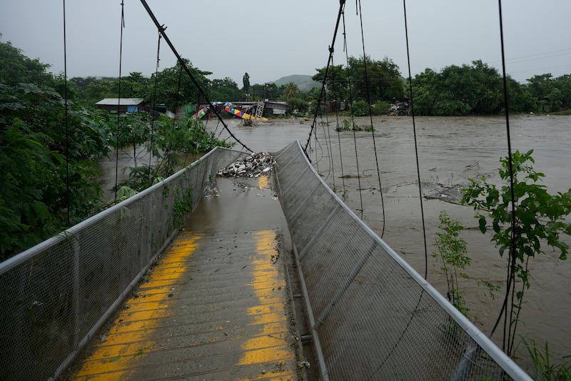 A pedestrian bridge collapsed after flooding caused by rains brought on by Tropical Storm Sara in San Pedro Sula, Hondura, on Saturday (Moises Castillo/AP)