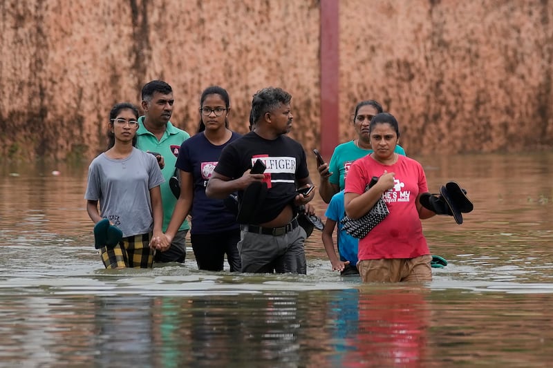 People wade through a submerged street in Colombo, Sri Lanka (Eranga Jayawardena/AP)