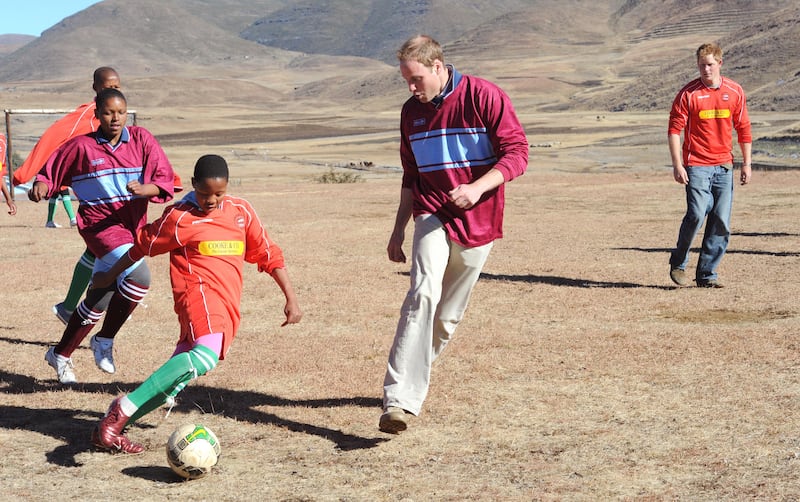 William and his brother Harry play football with orphaned children during a visit to the Semongkong Children’s Centre in Lesotho in 2010