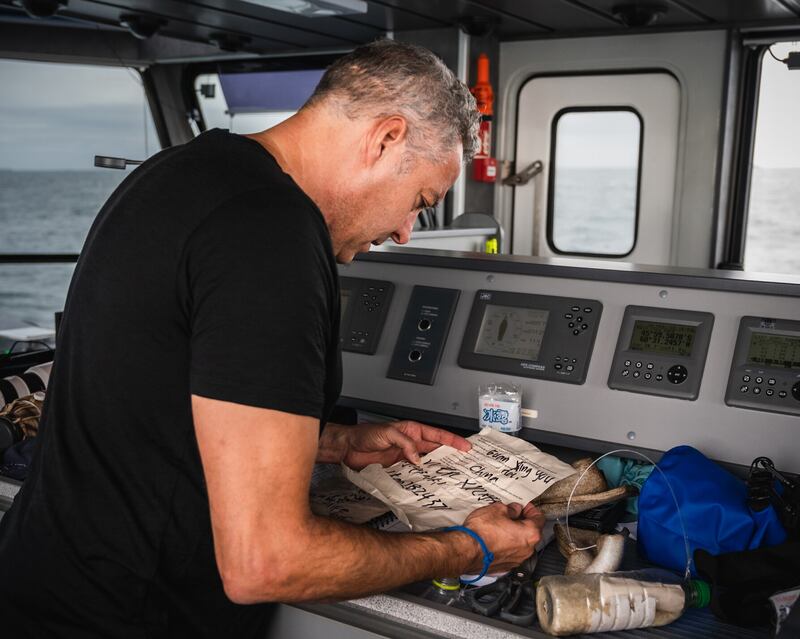 Ian Urbina from the Ocean Outlaw Project reading a questionnaire he had thrown on board a Chinese fishing vessel for crew members to complete. Picture by Youenn Kerdavid/Sea Shepherd Global