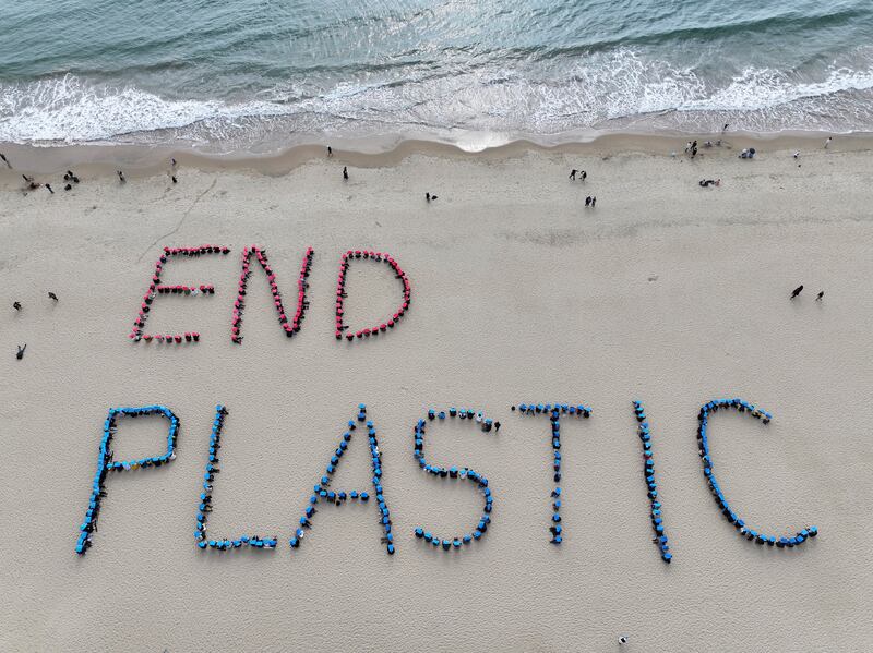 Environment activists perform a human sign calling for a strong global plastics treaty ahead of the fifth session of the Intergovernmental Negotiating Committee on Plastic Pollution (Son Hyung-joo/Yonhap via AP)