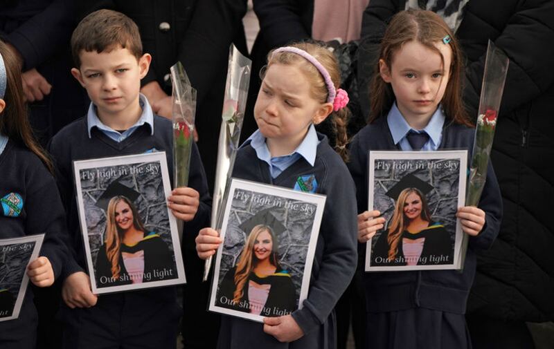 Schoolchildren taught by Ashling Murphy hold photographs of her as the cortege passes by on arrival at St Brigid's Church, Mountbolus, Co Offaly. Picture by Niall Carson/PA Wire &nbsp;