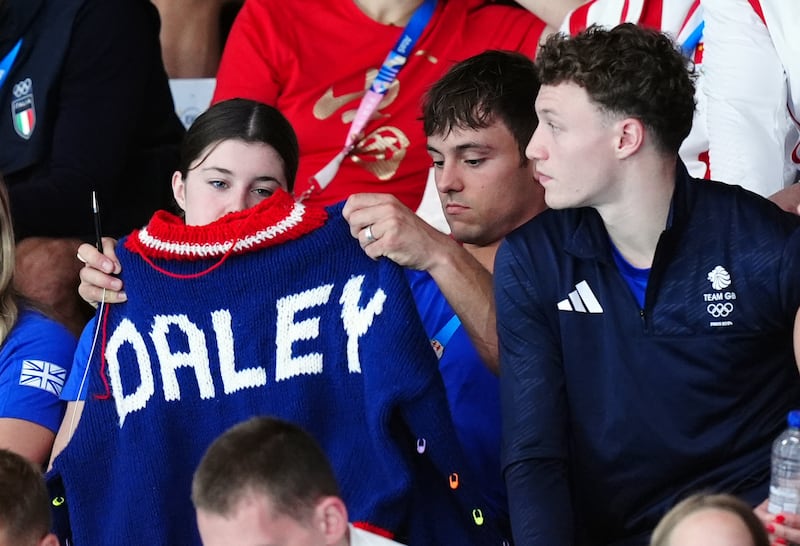 Tom Daley holds up his latest knitwear creation