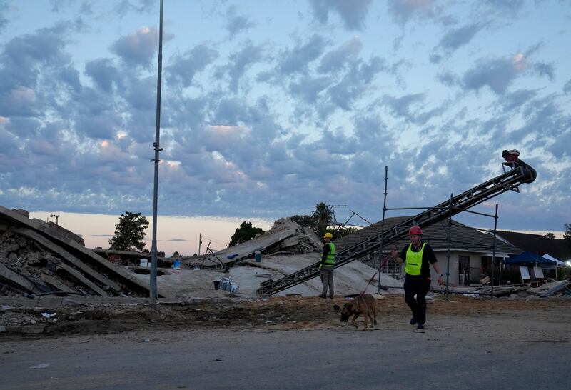 A rescue worker walks with a sniffer dog at the site of the building collapse in George, South Africa (Nardus Engelbrecht/AP)
