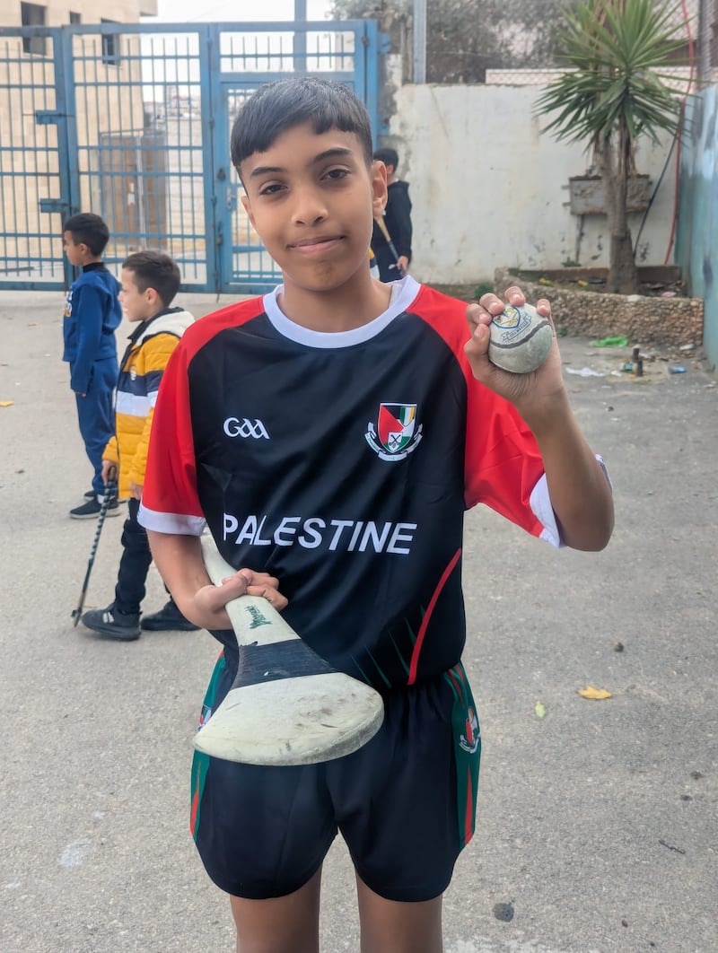 A young boy in Palestine enjoying playing hurling