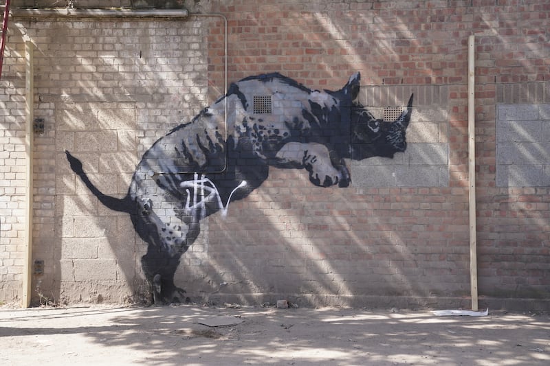 The defaced artwork unveiled by Banksy, depicting a rhinoceros which looked as though it was climbing on top of a car