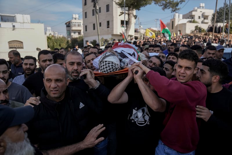 Mourners carry the body of Naji al-Baba, 16, who the Palestinian Health Ministry said was killed by Israeli forces in the town of Halhul, West Bank (Mahmoud Illean/AP)