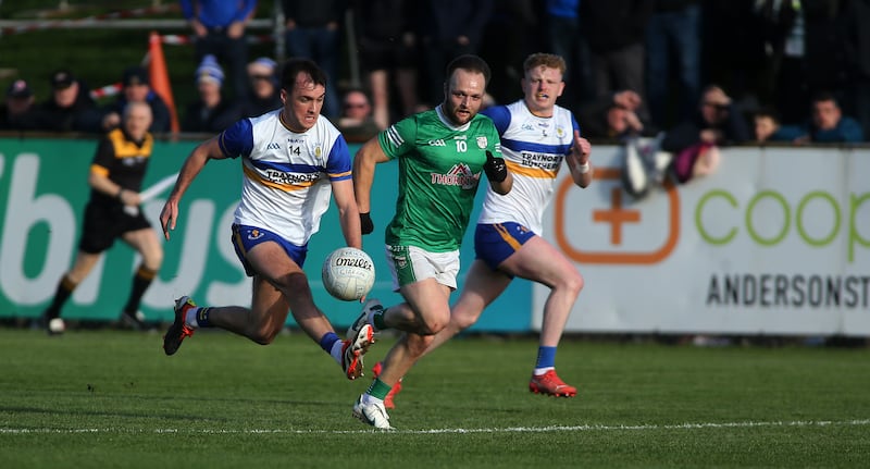 Errigal Ciaran captain Darragh Canavan solos away from Cargin's David Johnston with Peter Og Mc Cartan in support at Corrigan Park.