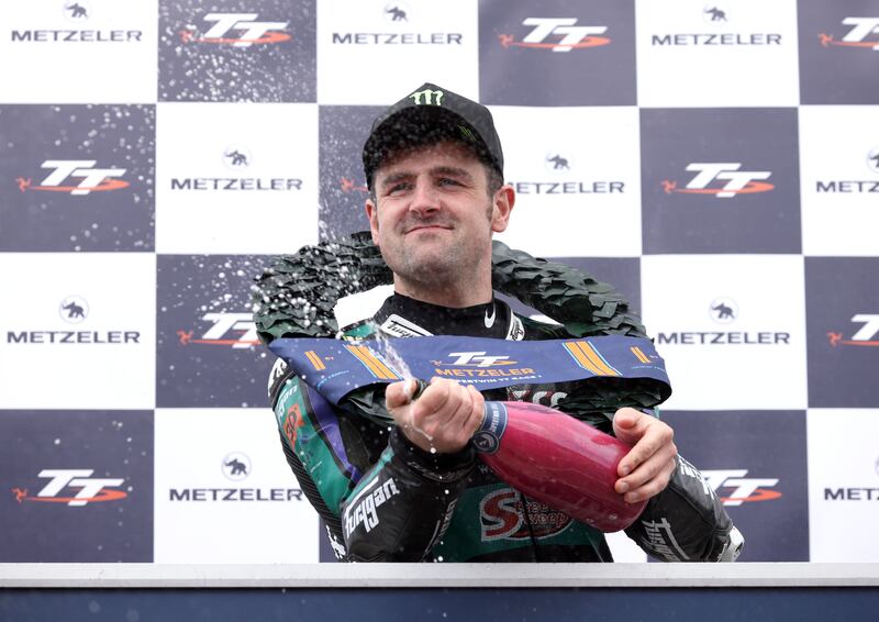 Michael Dunlop spraying a bottle of champagne after winning his 27th TT  race