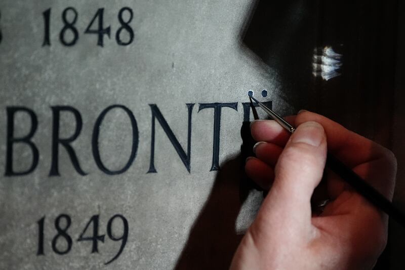 Conservator Lucy Ackland adds the finishing touches to the memorial to Charlotte, Emily and Anne Bronte at Poets’ Corner in Westminster Abbey, London