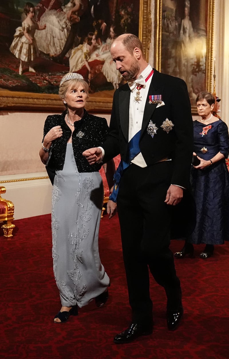 The Viscountess Hood and The Prince of Wales make their way along the East Gallery to attend the state banquet