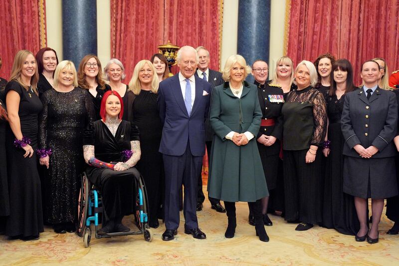 The Military Wives Choir pose for a photo with Charles and Camilla at Buckingham Palace