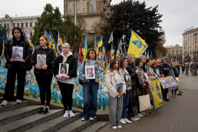 People held photos of their relatives during a nationwide minute’s silence in memory of fallen soldiers (Efrem Lukatsky/AP)