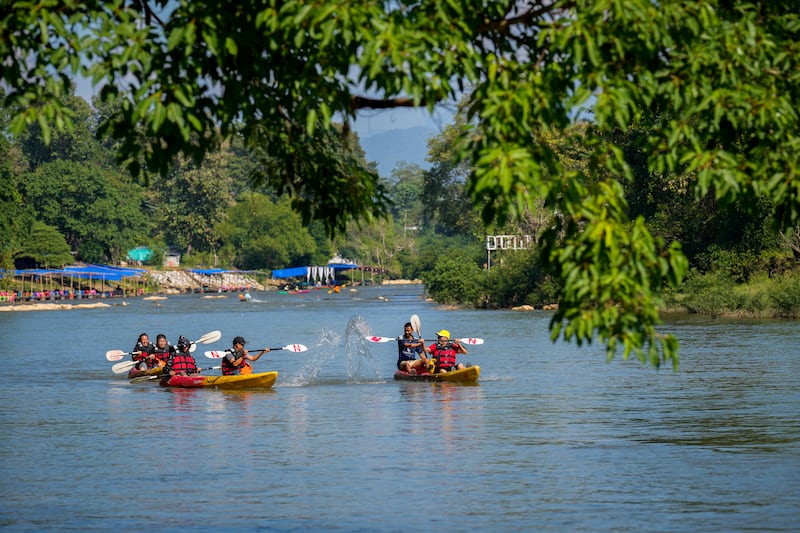 Foreign tourists ride on kayaks in Namsong river in Vang Vieng, Laos (Anupam Nath/AP)