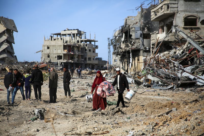 Palestinians inspect the destruction caused by the Israeli air and ground offensive in Rafah, as a ceasefire deal between Israel and Hamas went into effect (Mohammad Hajjar/AP)