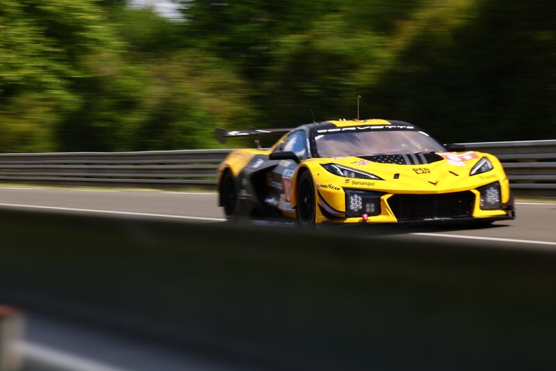 A yellow Corvette Racing team car with he number 81 on it driving on a track