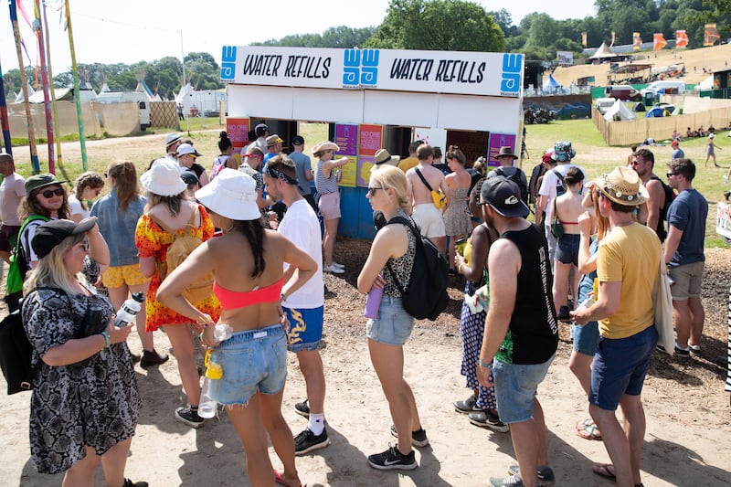 Festival-goers queue for the water refill station at the Glastonbury Festival