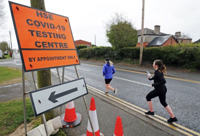 Joggers pass a sign for a testing centre in Newbridge in Co Kildare as the Covid-19 crisis continues. Picture by Niall Carson, Press Association 