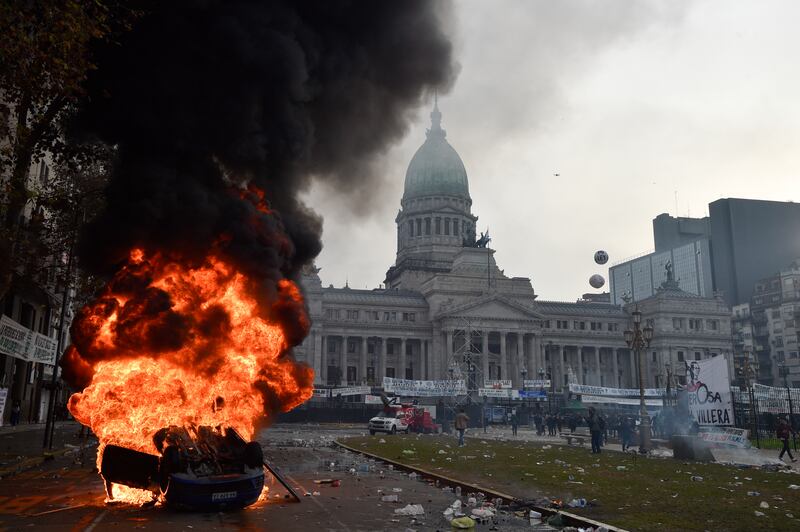 A car burns during clashes between police and anti-government protesters in Buenos (Gustavo Garello/AP)