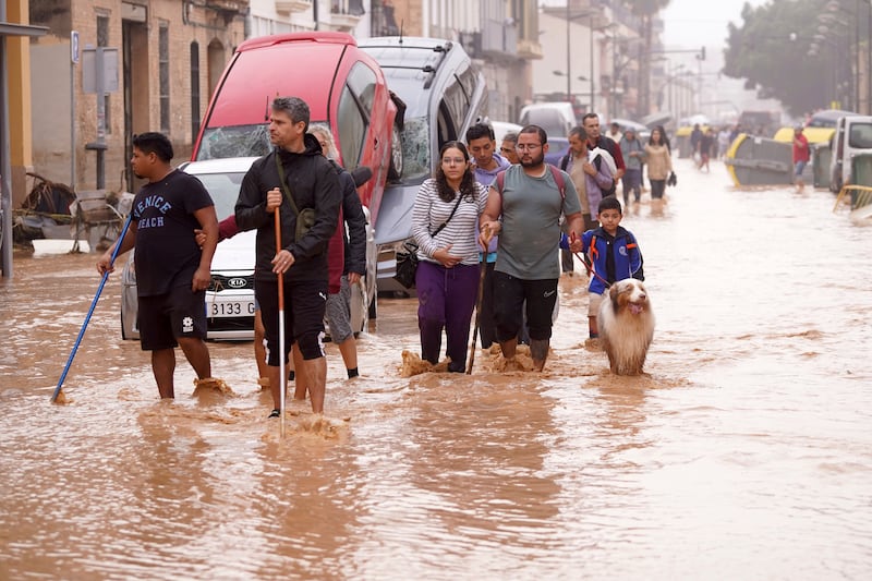 People walk through flooded streets in Valencia (Alberto Saiz/AP)