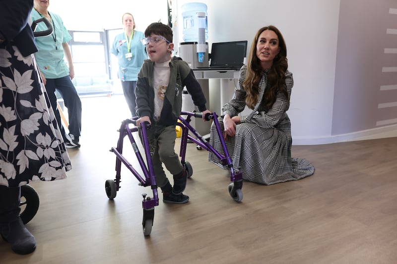 Kate crouching down to meet a youngster as she visits Ty Hafan Children’s Hospice